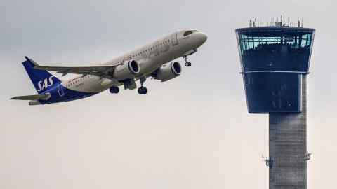 A plane takes off next to an air tower at Copenhagen Airport, Kastrup in Denmark