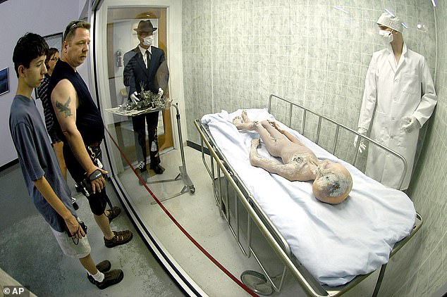 Tales of the Roswell UFO crash remain an unusual profit center for the small desert town. Above, El Paso, Texas residents - visiting Roswell's International UFO Museum and Research Center in June of 2004 - take in a display replicating the long-alleged alien autopsy