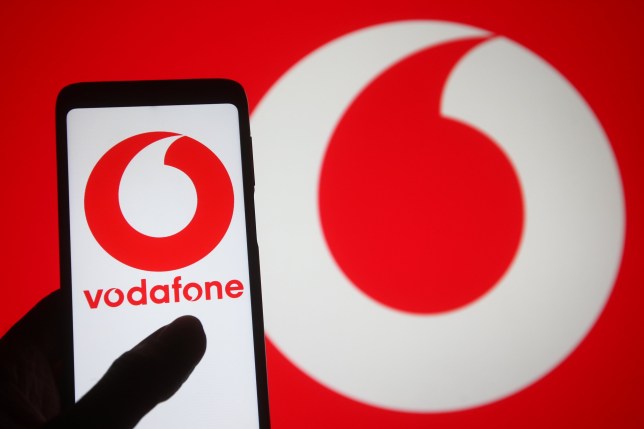 UKRAINE - 2021/03/10: In this photo illustration, the Vodafone logo of a multinational telecommunications company seen displayed on a smartphone into a silhouette of a hand. (Photo Illustration by Pavlo Gonchar/SOPA Images/LightRocket via Getty Images)
